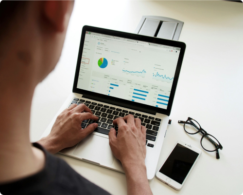 A person working on a laptop looking at financial data